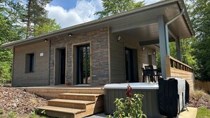 Een modern huis met een stenen gevel, een overdekte veranda en een hottub.