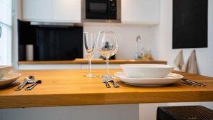 Una cocina moderna con encimera de madera, dos copas de vino, un bol y cubiertos.