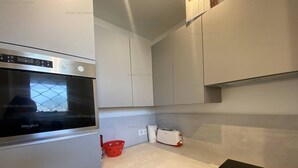 Una cocina moderna con horno Whirlpool empotrado, placa de inducción negra y muebles de cocina blancos.