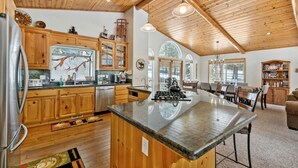 Una cocina amplia con armarios de madera, una isla grande y un comedor con vistas al exterior.