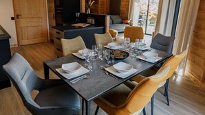 Ein moderner Essbereich mit einem rechteckigen Tisch, gedeckt für sechs Personen, umgeben von zeitgenössischen Stühlen.