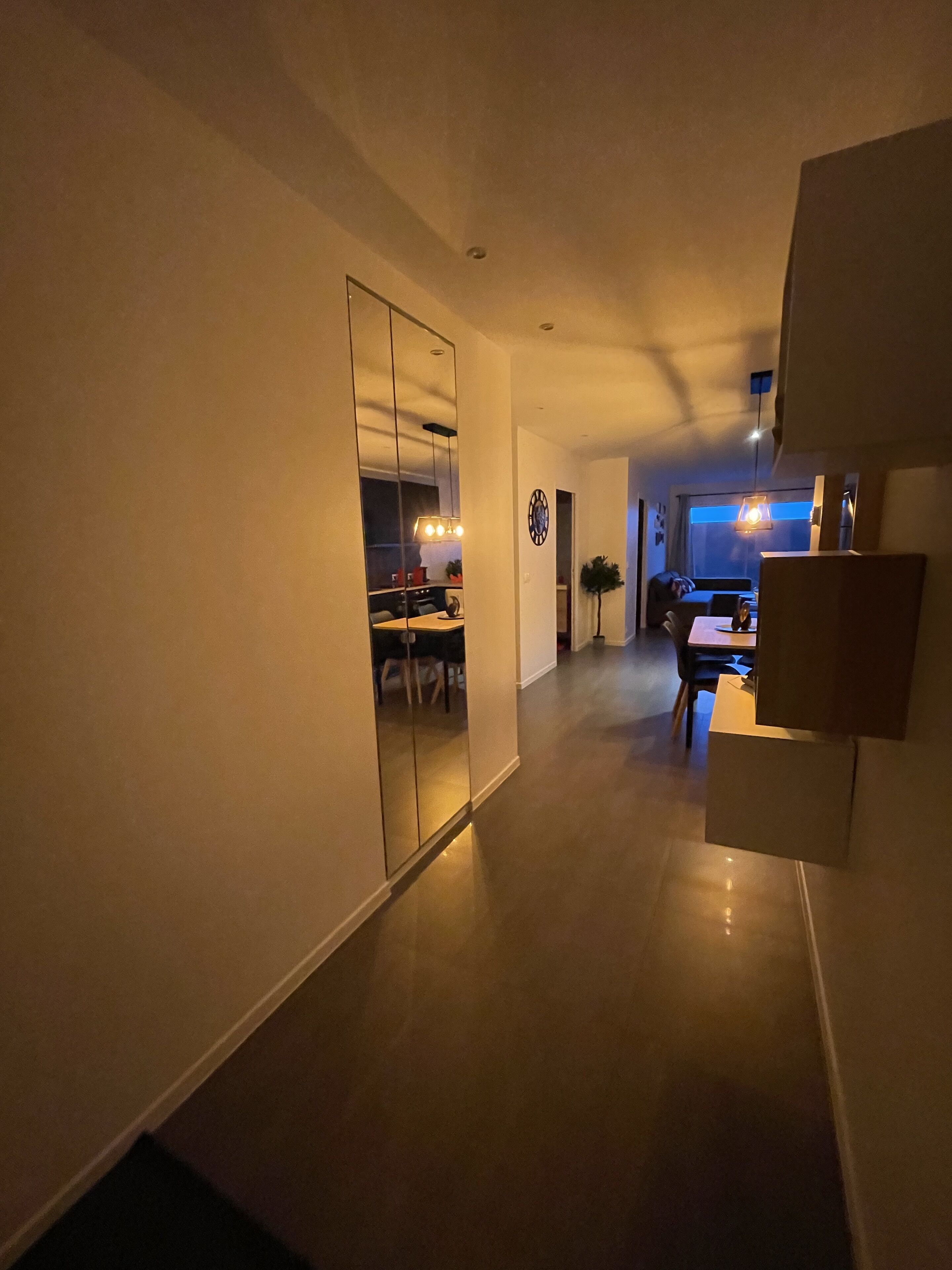 Un interior moderno con un pasillo que conduce a un comedor y una sala de estar.