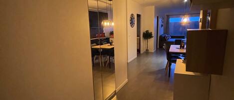 Un interior moderno con un pasillo que conduce a un comedor y una sala de estar.