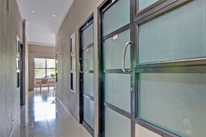 Corridors feature glass doors with metal handles, a chair for seating, and a tiled floor.