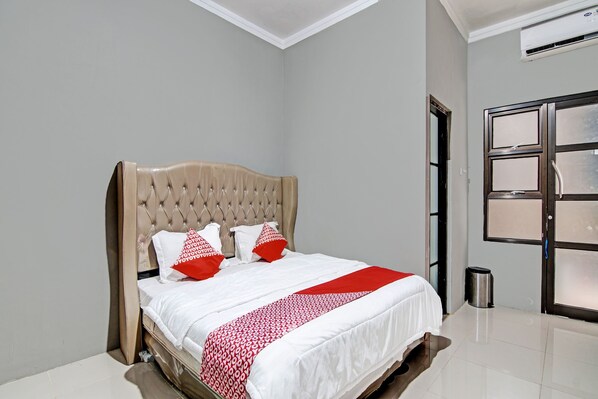 Relax in a stylish room with a large bed, tufted headboard, and minimalist decor.