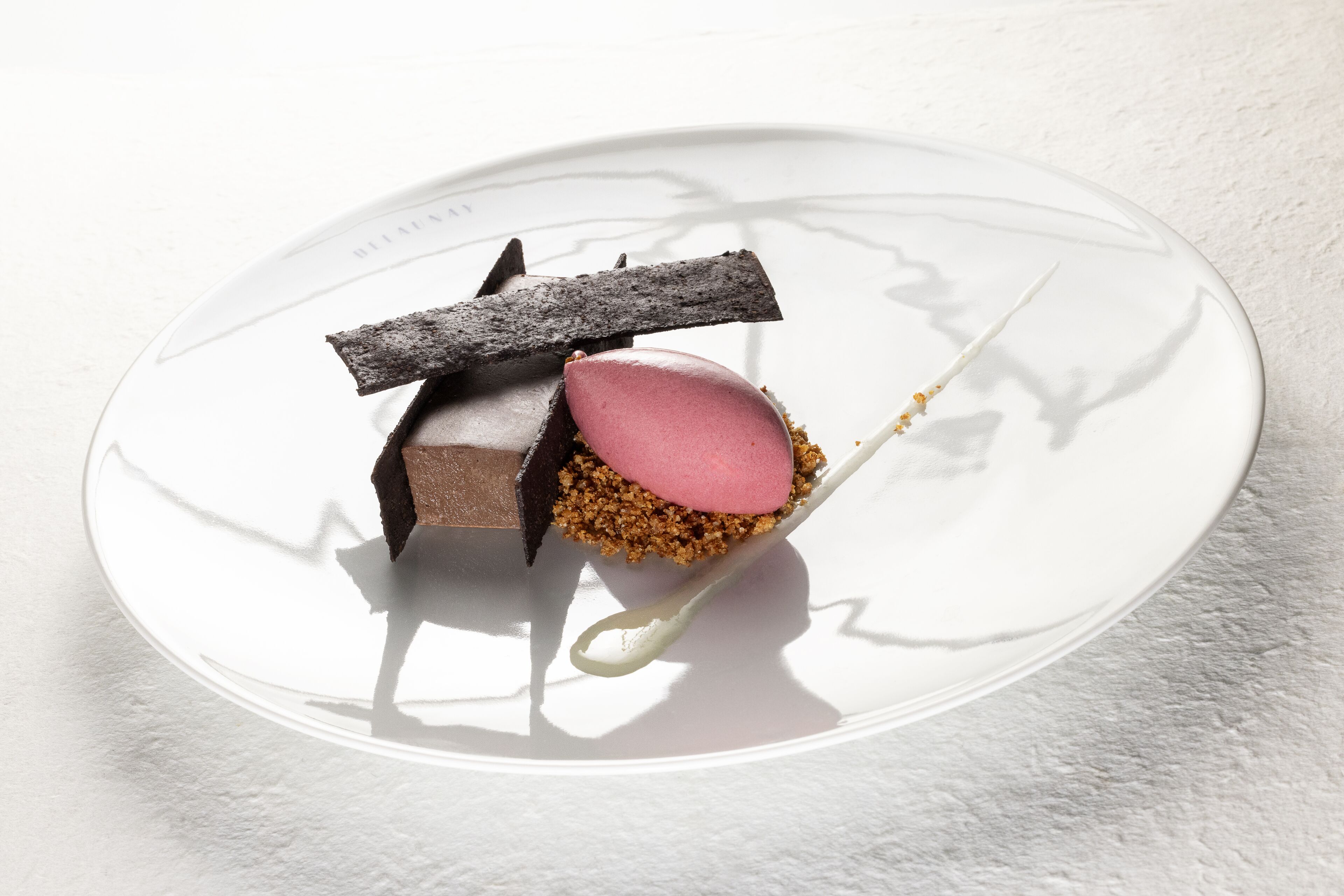 A dessert on a white plate with a spoon.