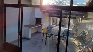 A balcony with a grill, chairs, and a table. - Villa Remparts (Pernes-les-Fontaines)