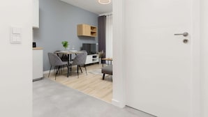 Una cocina moderna con comedor, un armario empotrado de madera y una silla tapizada en gris.