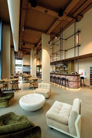 A spacious restaurant with high ceilings, exposed beams, and a bar area with stools. - Hotel Jansen Amsterdam Bajeskwartier (Amsterdam)