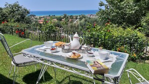 A table set outdoors with a view of the sea and a book titled 'Annie'. - Villa with Breathtaking Seaview, Private Swimming Pool & Jacuzzi (Corfu)