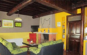Un salon chaleureux avec deux canapés, une cheminée et un téléviseur.