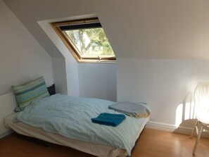 A small, single-bed room with a sloped ceiling and a skylight. - Bothy near the woods (Nethy Bridge)