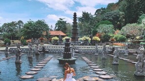 A serene garden with a central pond, surrounded by statues and a pagoda. - AlamGangga Villas Tirta Gangga (Karangasem)