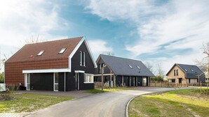 Un quartier résidentiel avec des maisons modernes dotées de toits inclinés et de grandes fenêtres.