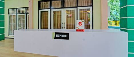 A reception desk with a sign reading "RECEPTIONIST" and a sign indicating a smoking area.