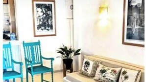 A living room with a sofa, two chairs, a coffee table, and a small table with a plant.