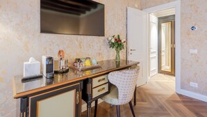 A modern kitchen with a large flat-screen TV, a coffee machine, and a vase with flowers on the counter. - 312 Piazza San Marco (Venice)