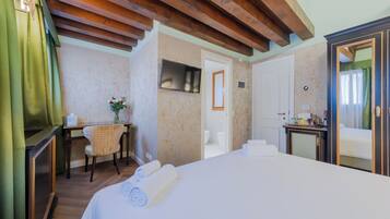 Une chambre d’hôtel comprenant un lit, un bureau, une chaise, une télévision et une salle de bain.