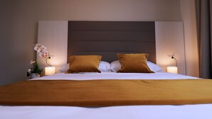 A hotel room with a large bed, two pillows, a bedside table with a lamp, and a potted plant. - BLU HOTEL 4 4 S.R.L. (Buccinasco)