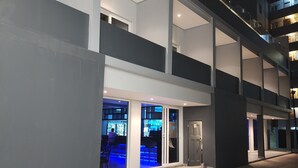A modern building with a flat roof, large windows, and a covered outdoor area with seating. - 12 Oceans Hotel and Conference Centre (Kingsburgh)