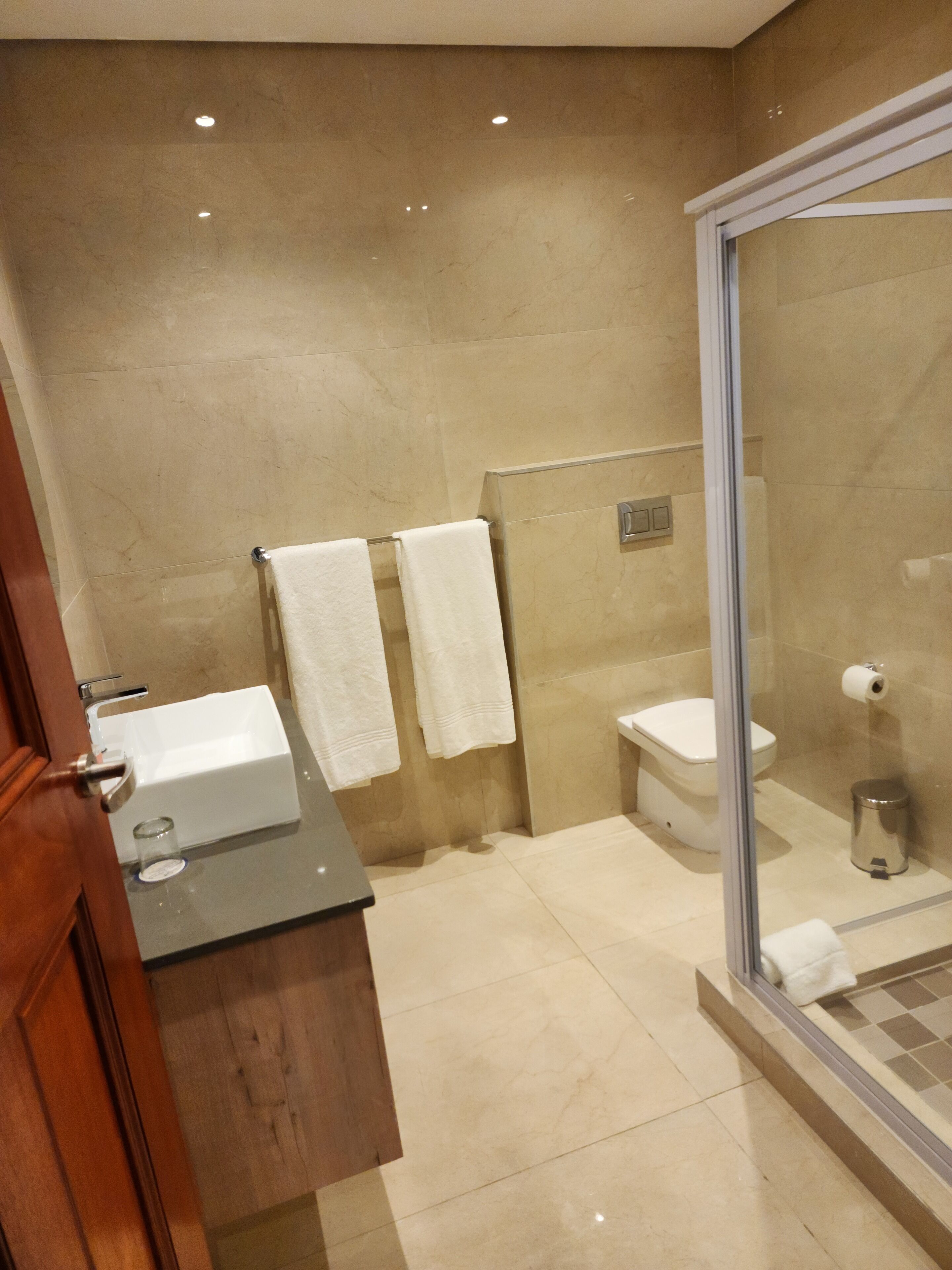 A modern bathroom with a sink, toilet, and shower.