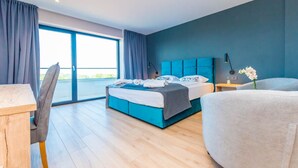 A modern hotel room with a large bed, a desk, and a chair. There is a large window providing a view of the outdoors. - Hotel Delfin Lanterna (Tar-Vabriga)