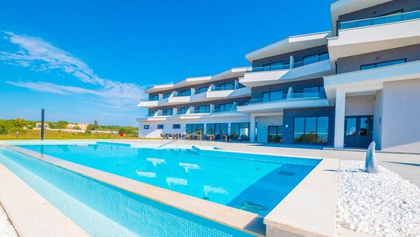 A modern hotel with a swimming pool, multiple balconies, and a clear blue sky. - Hotel Delfin Lanterna (Tar-Vabriga)