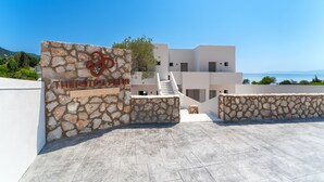 A modern building with a stone entrance labeled "THERETRO SEAS." - Theretra Pefki Seaside (Rhodes)