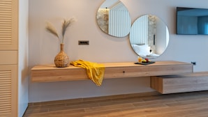 A modern living room with a wooden console table, a vase with dried plants, and two wall-mounted mirrors. - Theretra Pefki Seaside (Rhodes)