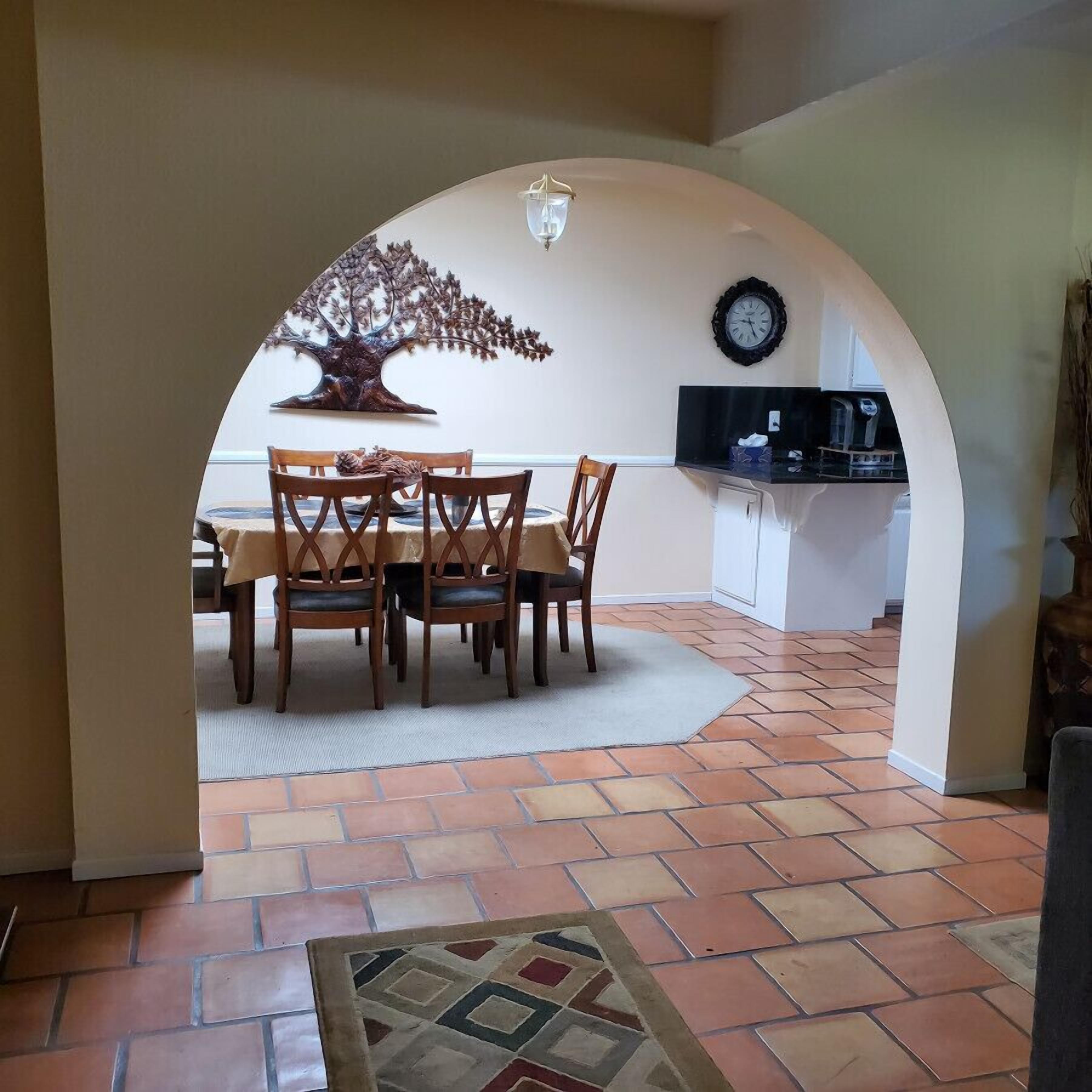 An interior with a dining area, a kitchen, and a living space.