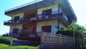 Un immeuble à plusieurs étages doté de balcons et d’une entrée sécurisée par un portail.