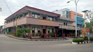 Un hôtel appelé « Sumber Mulya », doté d’une façade moderne, de nombreuses fenêtres et d’un espace d’entrée abrité.