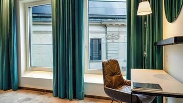 A room with a window, a table, a chair, and a lamp.