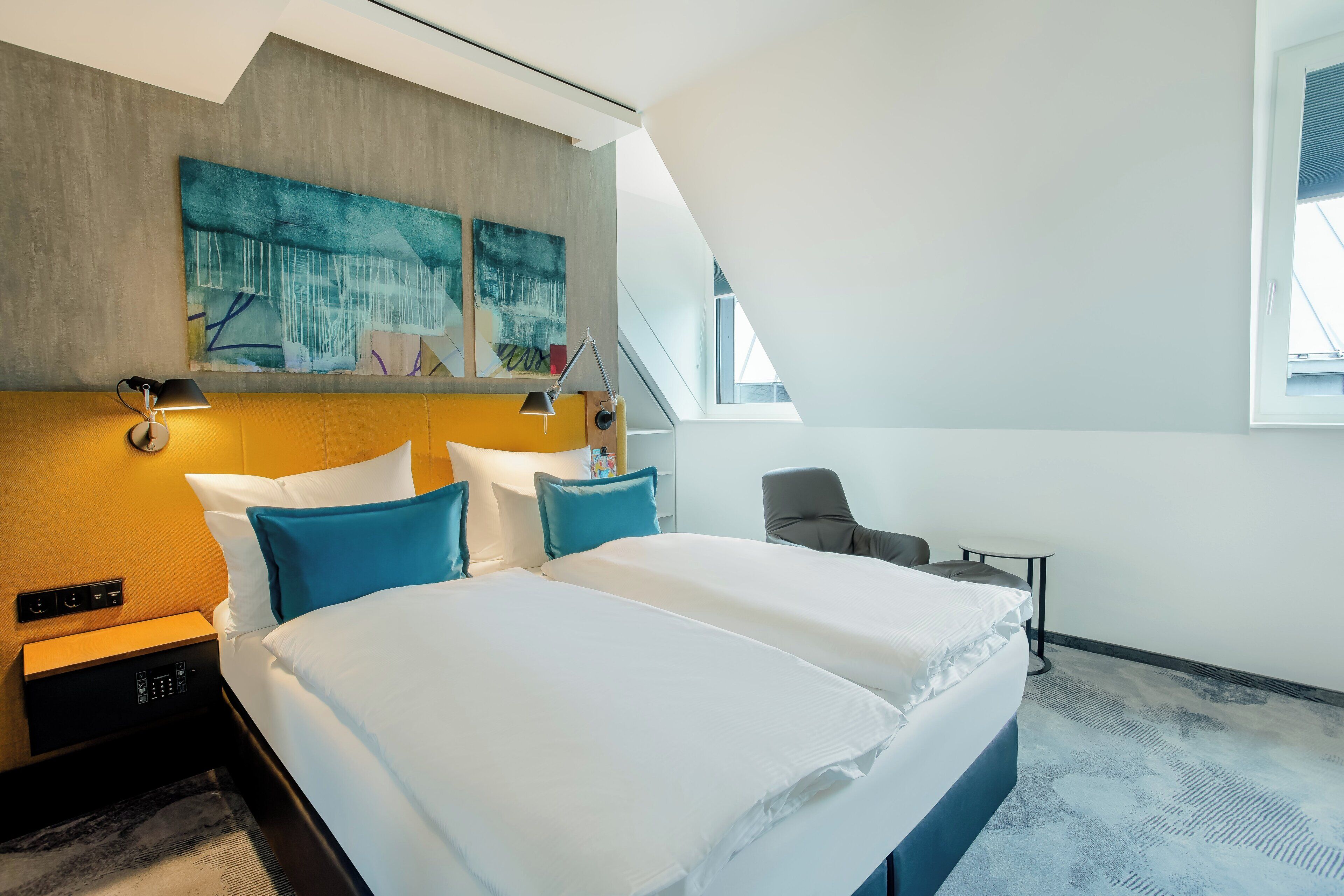 Une chambre d’hôtel avec un lit, des tables de chevet, un bureau, une chaise et une fenêtre.