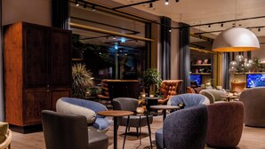 Un área de estar moderna con asientos cómodos, un mueble de madera y una televisión.