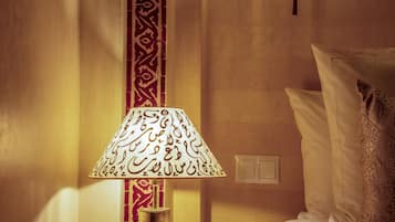 Una habitación con una cama, una lámpara de diseños intrincados y una pared con azulejos decorativos.