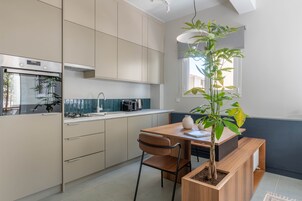 Una cocina moderna con una mesa de madera, una silla y una planta en maceta.