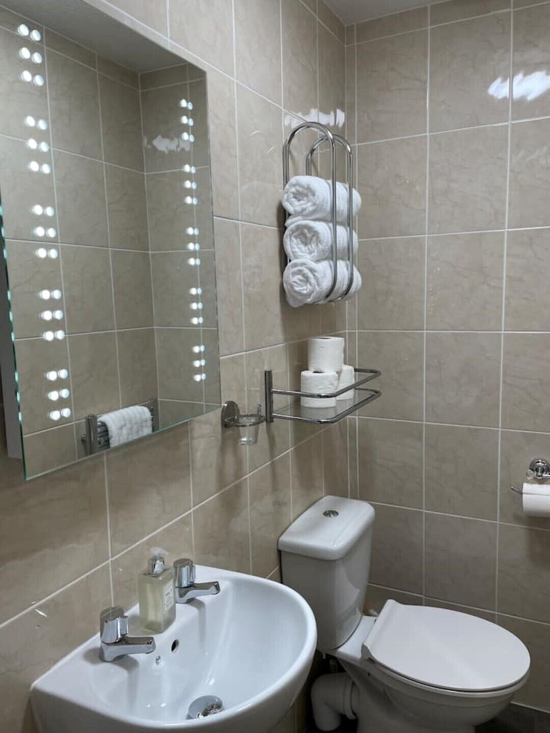 Une salle de bain avec un lavabo, des toilettes et un miroir.