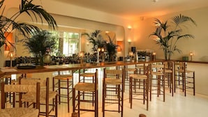 Een bar met meerdere houten barstoelen en een lange bar.