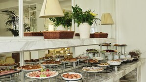 Een buffet met diverse gerechten en een spiegel die de ruimte weerspiegelt.