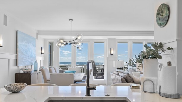 A modern kitchen with a large island, a view of the ocean, and a seating area with a view. - PANORAMIC GULF FRONT in WATERSOUND BRIDGES! VIEWS, OUTDOOR BALCONY, 30A Area (Watersound)