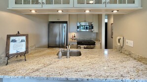 A kitchen with a stainless steel refrigerator, a microwave, a stove, and a sink. - Beachfront 2 bedroom condo, Glen Arbor (Glen Arbor)