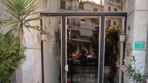 A building entrance with a glass door, potted plants, and a tiled floor. - Immaculate 2-bed Apartment in Zografou (Zografos)