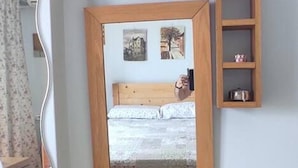 A wooden desk with a mirror, a small shelf, and a trash bin. - Immaculate 2-bed Apartment in Zografou (Zografos)