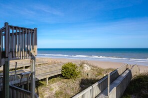 Una passerella in legno che conduce a una spiaggia con una vista libera sull'oceano.