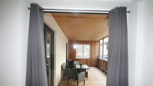 A corridor leading to a dining area with a table and chairs, wooden flooring, and a view through a glass door. - Apartment Lisa by Interhome (Achensee)