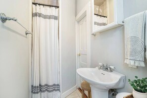 Chuveiro, secador de cabelo, toalhas de banho, papel higiênico