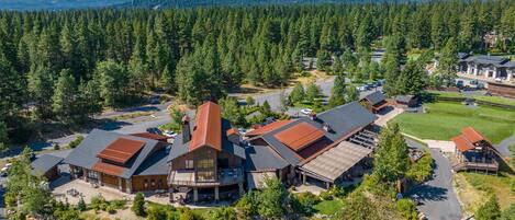 A lodge with multiple buildings, a parking area, and a forested backdrop.
