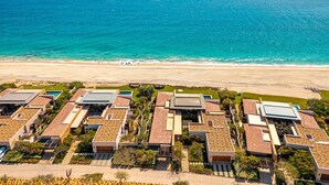 Een kustwoongebied met moderne huizen, een strand en helder uitzicht op de oceaan.