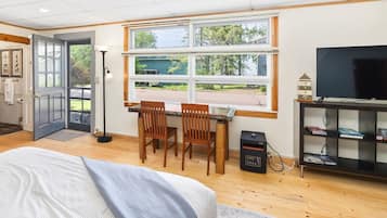 Une pièce comprenant un lit, un bureau avec deux chaises, une télévision et une bibliothèque.